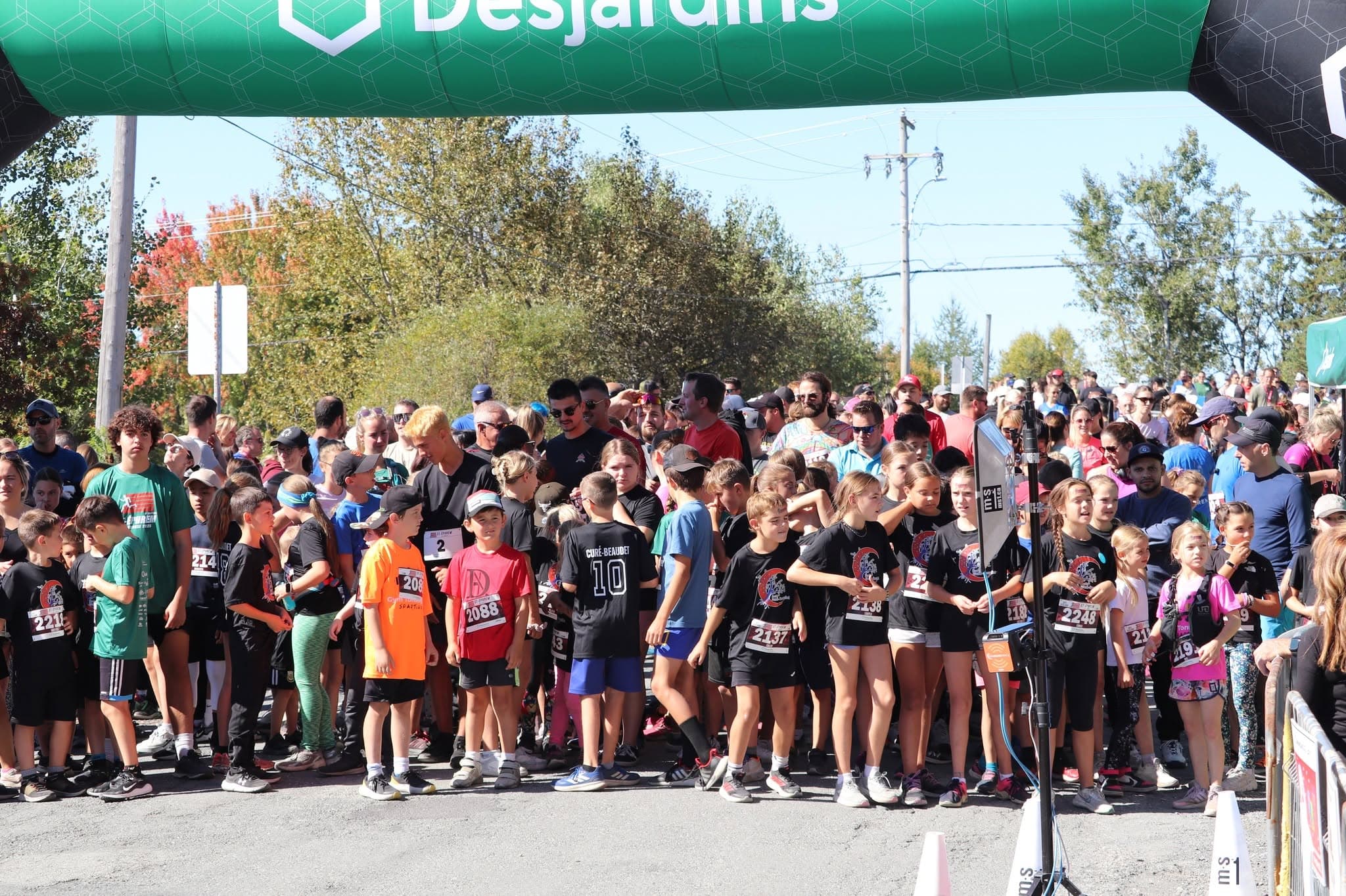 Familles, bénévoles et coureurs célébrant ensemble après la course